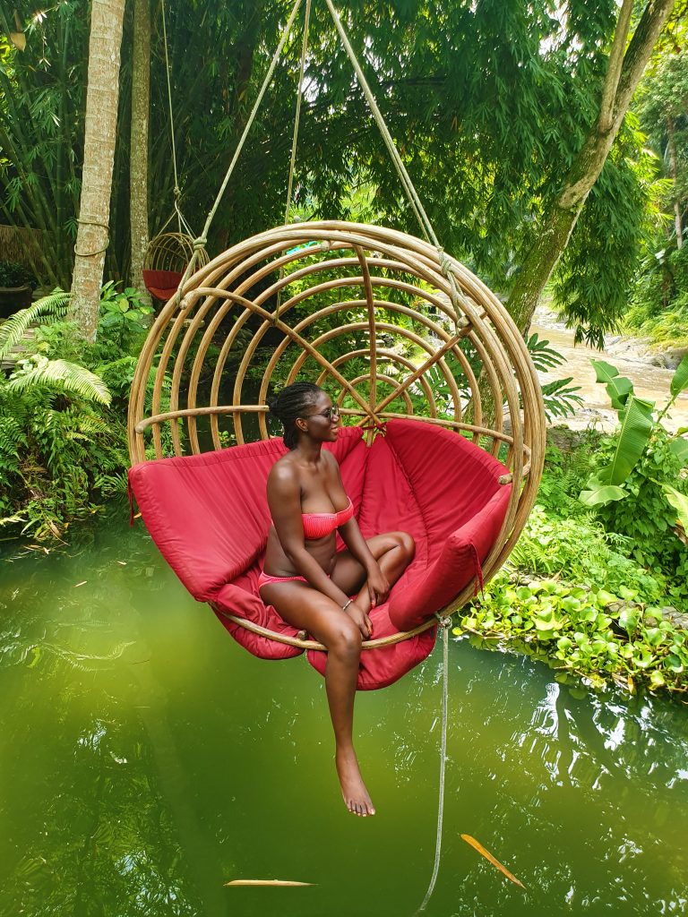 Person in a hanging chair over a lake in Ubud, Bali