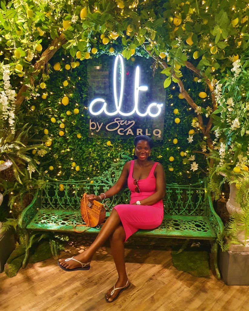 Sitting in front of Alto by San Carlo sign